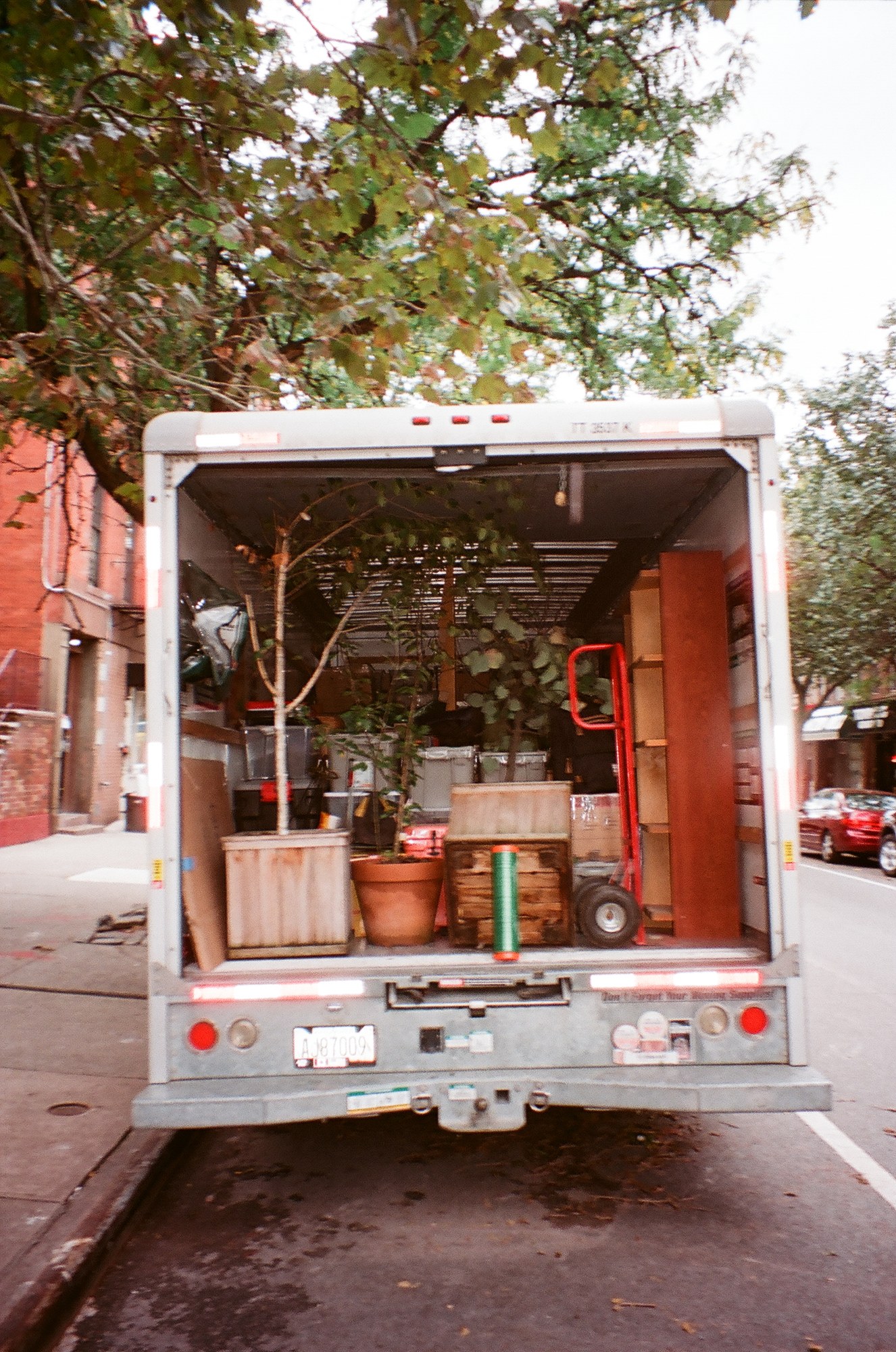 An open moving truck carrying furniture and objects.