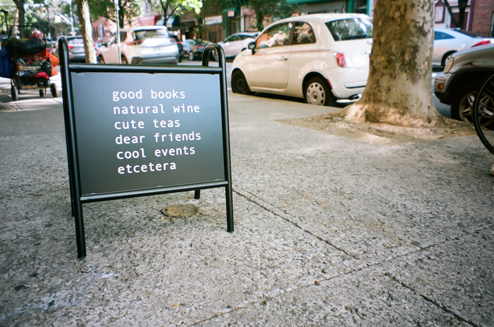 Dear Friend sidewalk sign listing books, wine, tea and events.